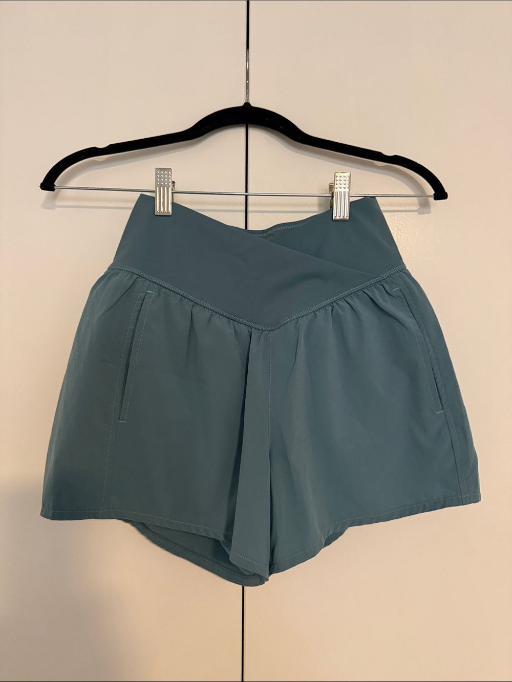 HALARA High-Rise Cross-Front Athletic Shorts in Teal with Pockets